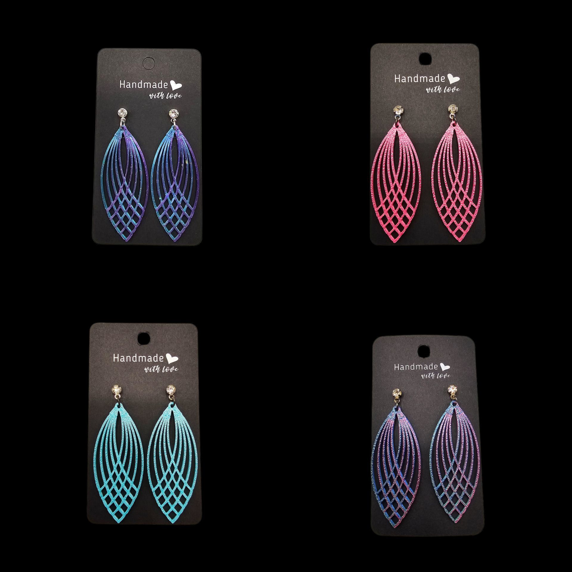 Vier paar druppelvormige hangende oorbellen in blauw, roze, turquoise en paars met een kristallen bovenkant, gepresenteerd op zwarte kaartjes.