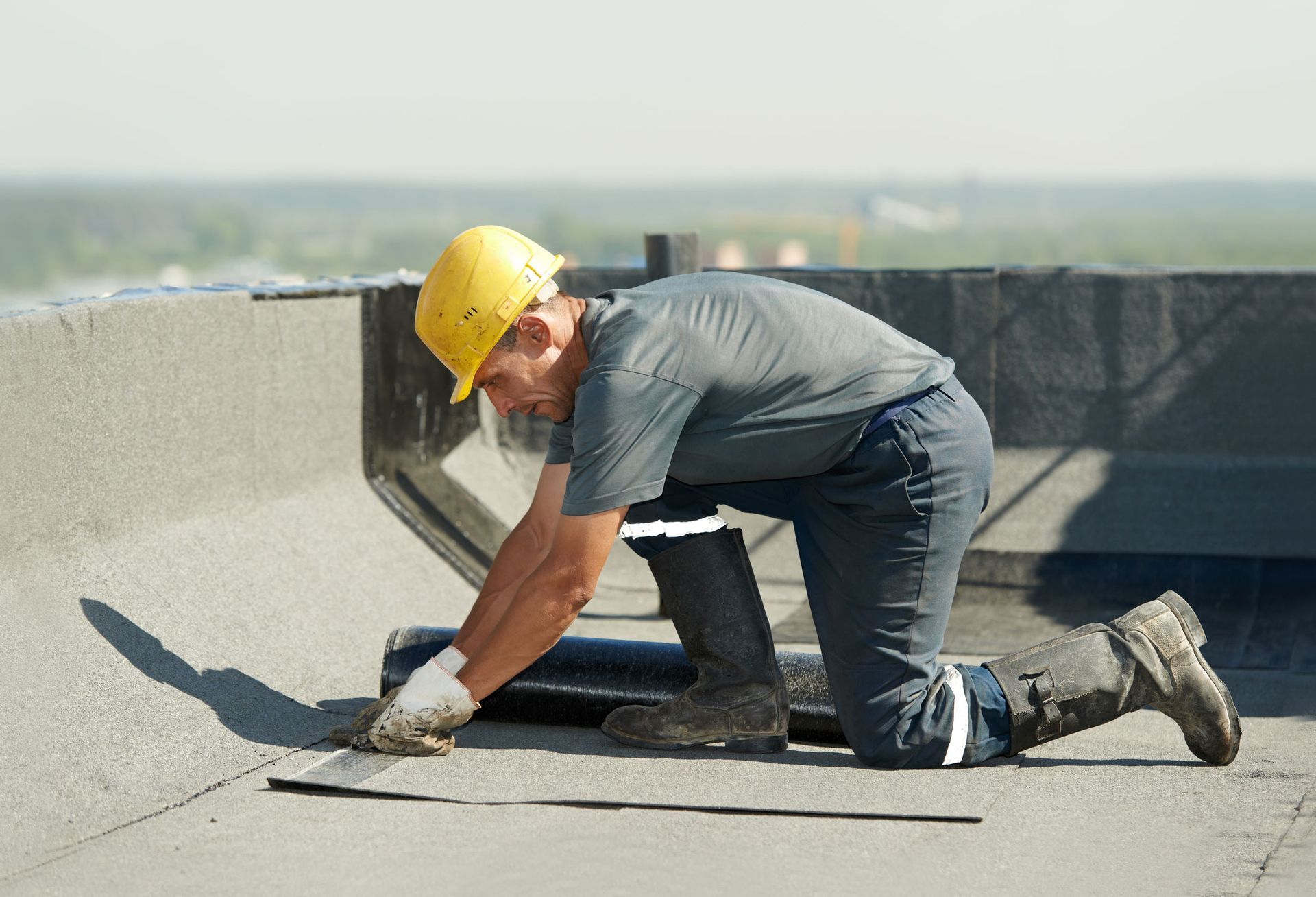 Professional roofer applying EPDM rubber roofing for DeShazo And Son Roofing Inc in Richmond, VA. Du