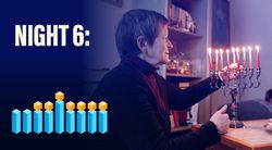 A senior lighting Chanukah candles