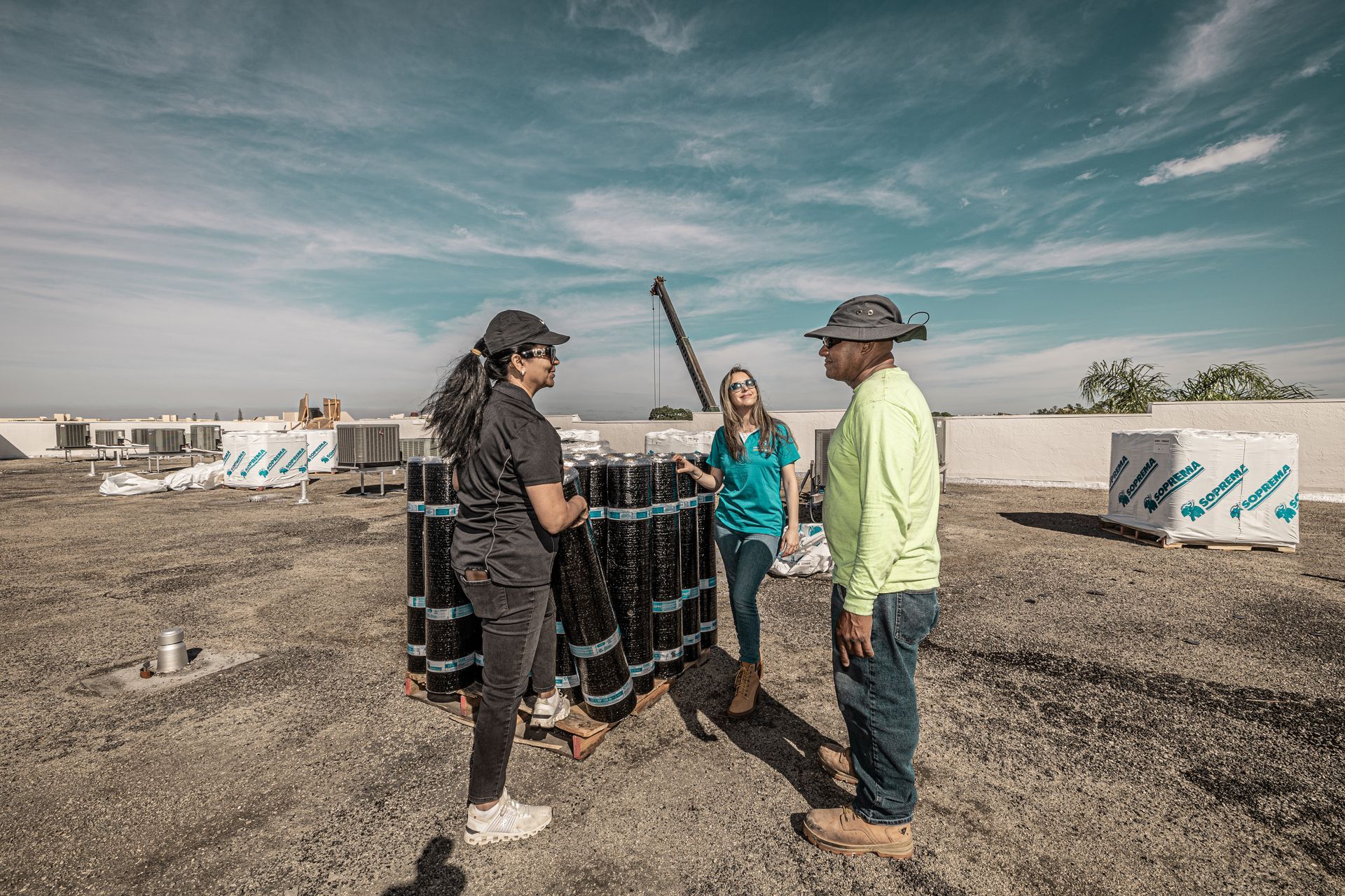 A group of people are standing on top of a dirt field talking to each other.