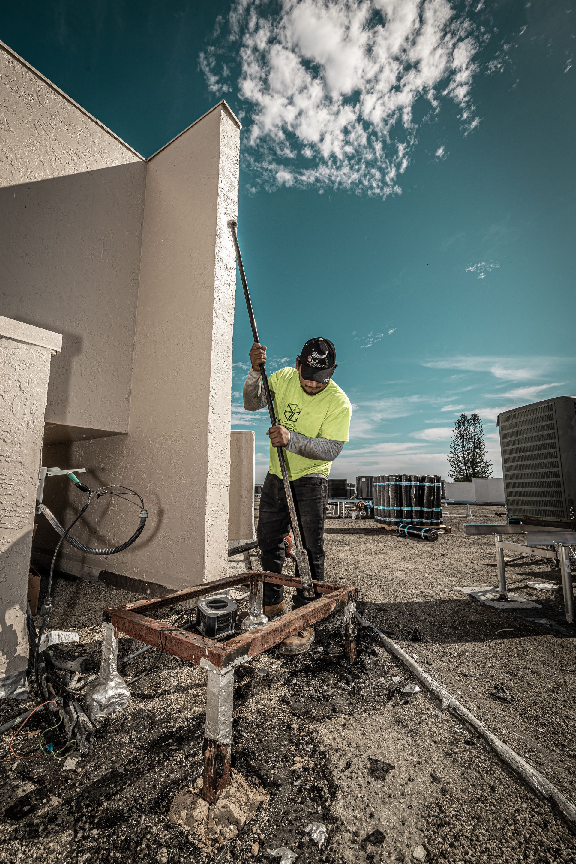 A man is digging a hole in the ground in front of a building.