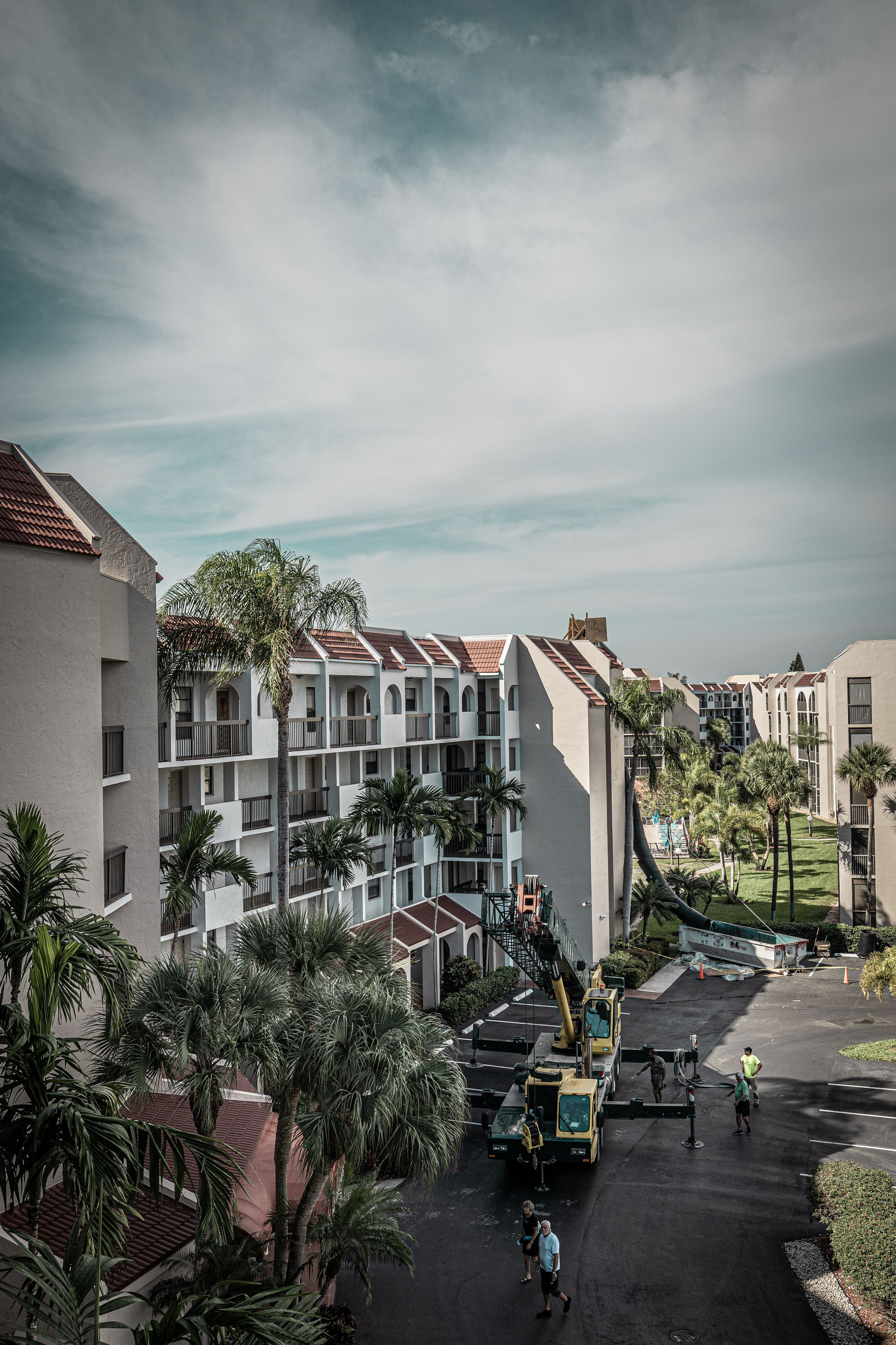 An aerial view of a building with a crane in front of it.