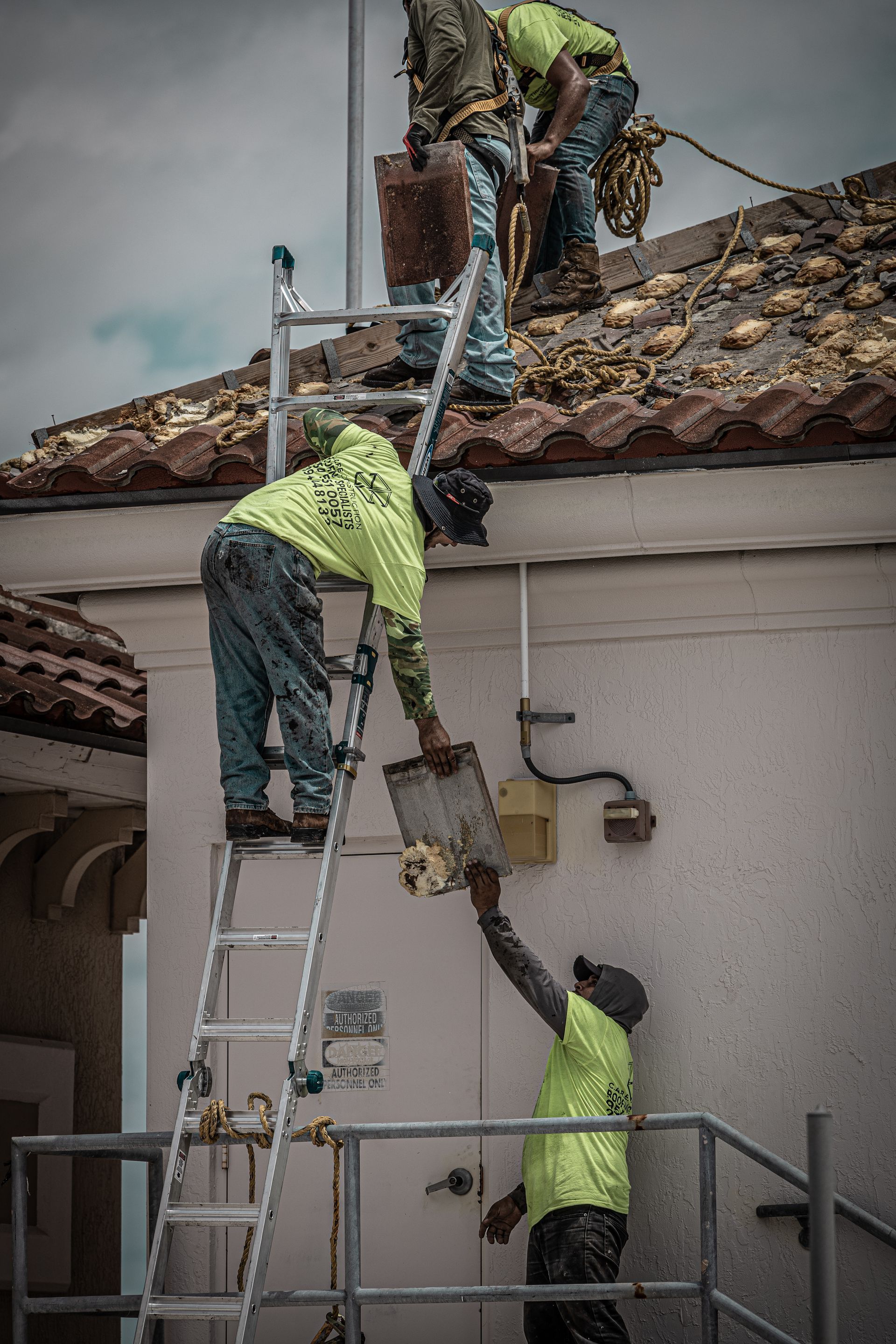 A group of men are working on the roof of a building.