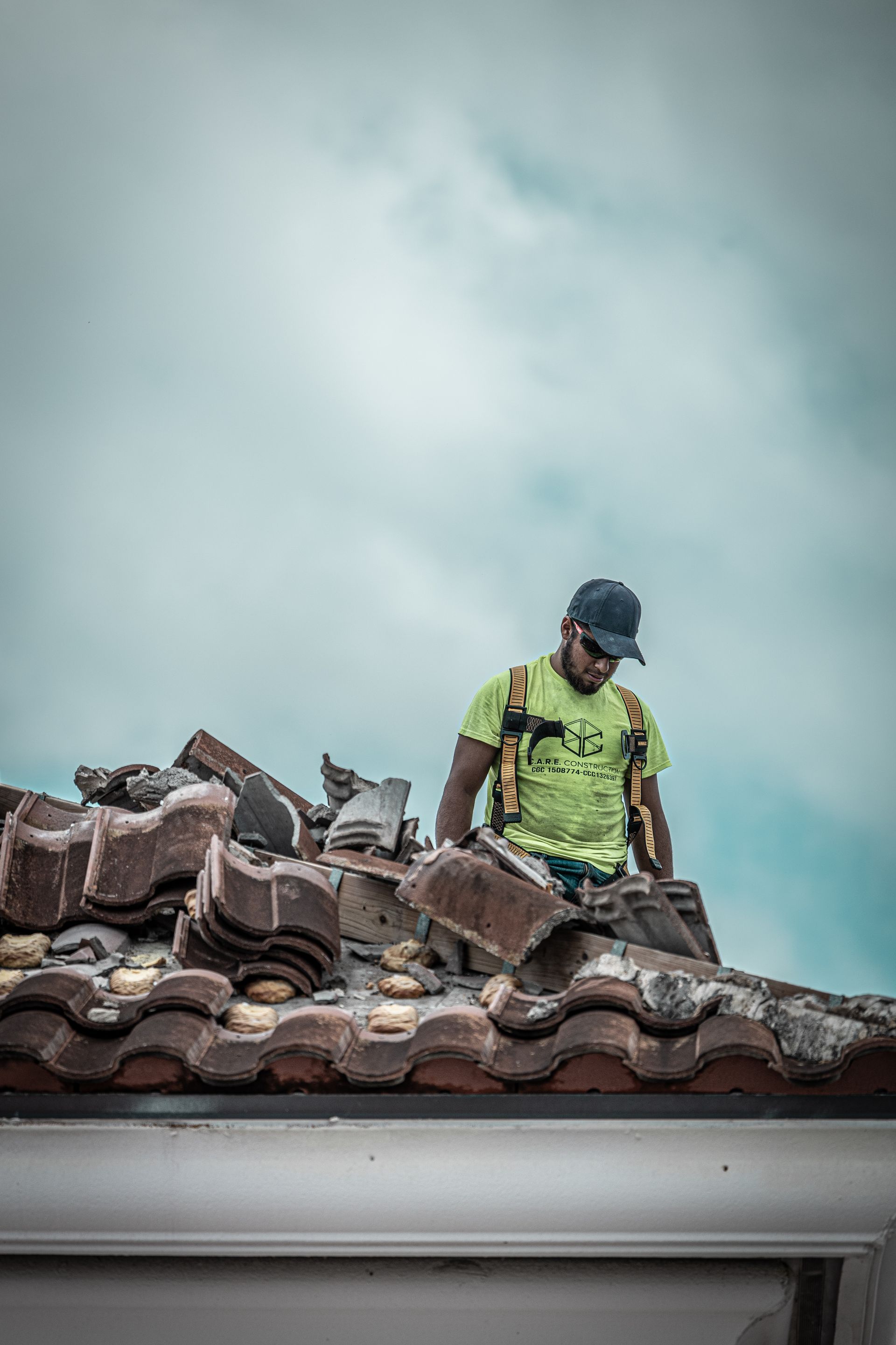 A man is standing on top of a tiled roof.