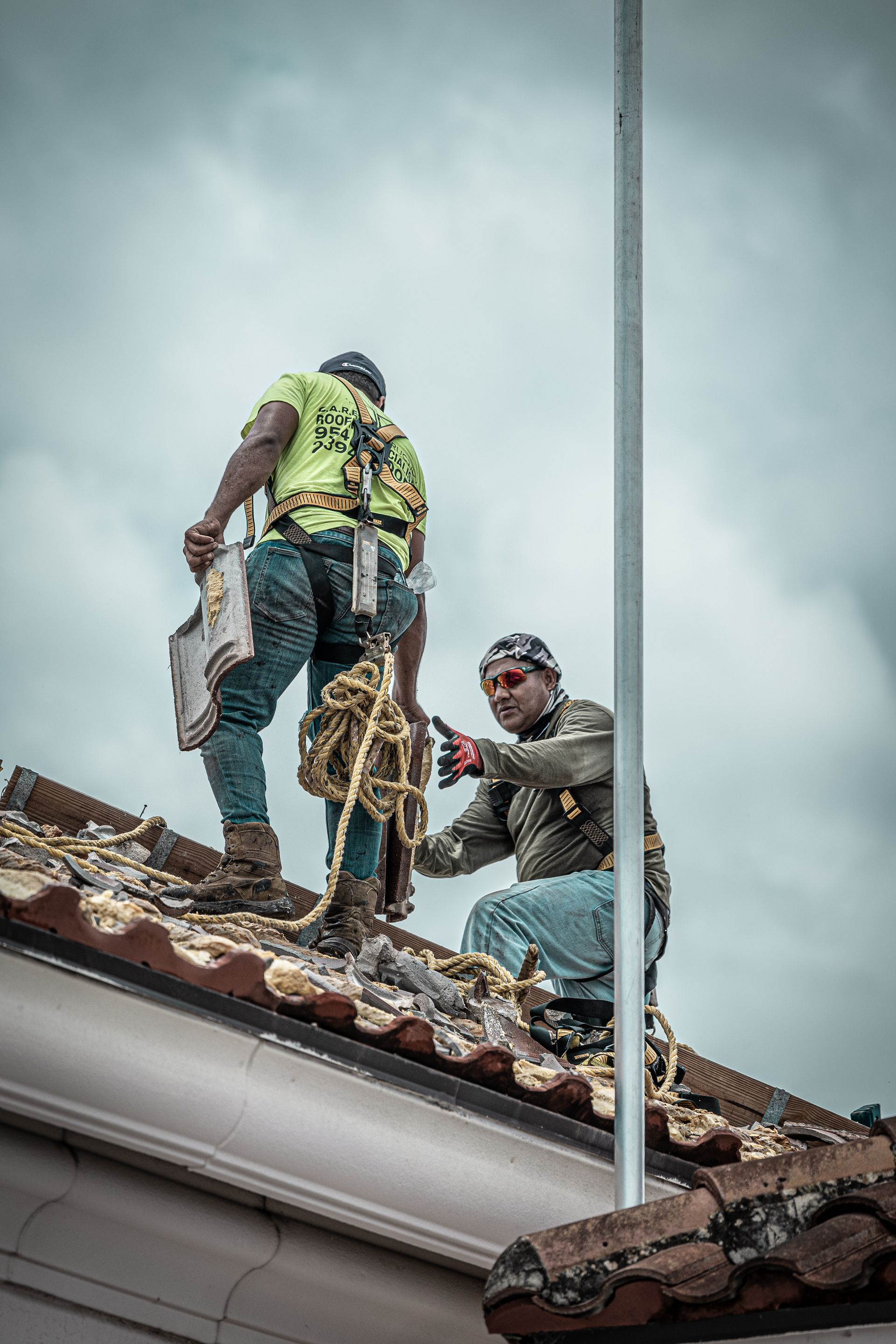 Two men are working on the roof of a building.