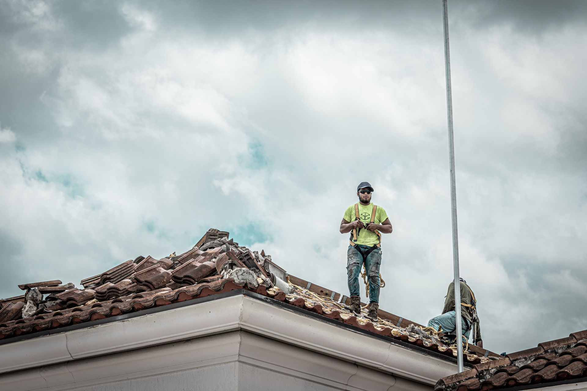 Two men are standing on the roof of a building.