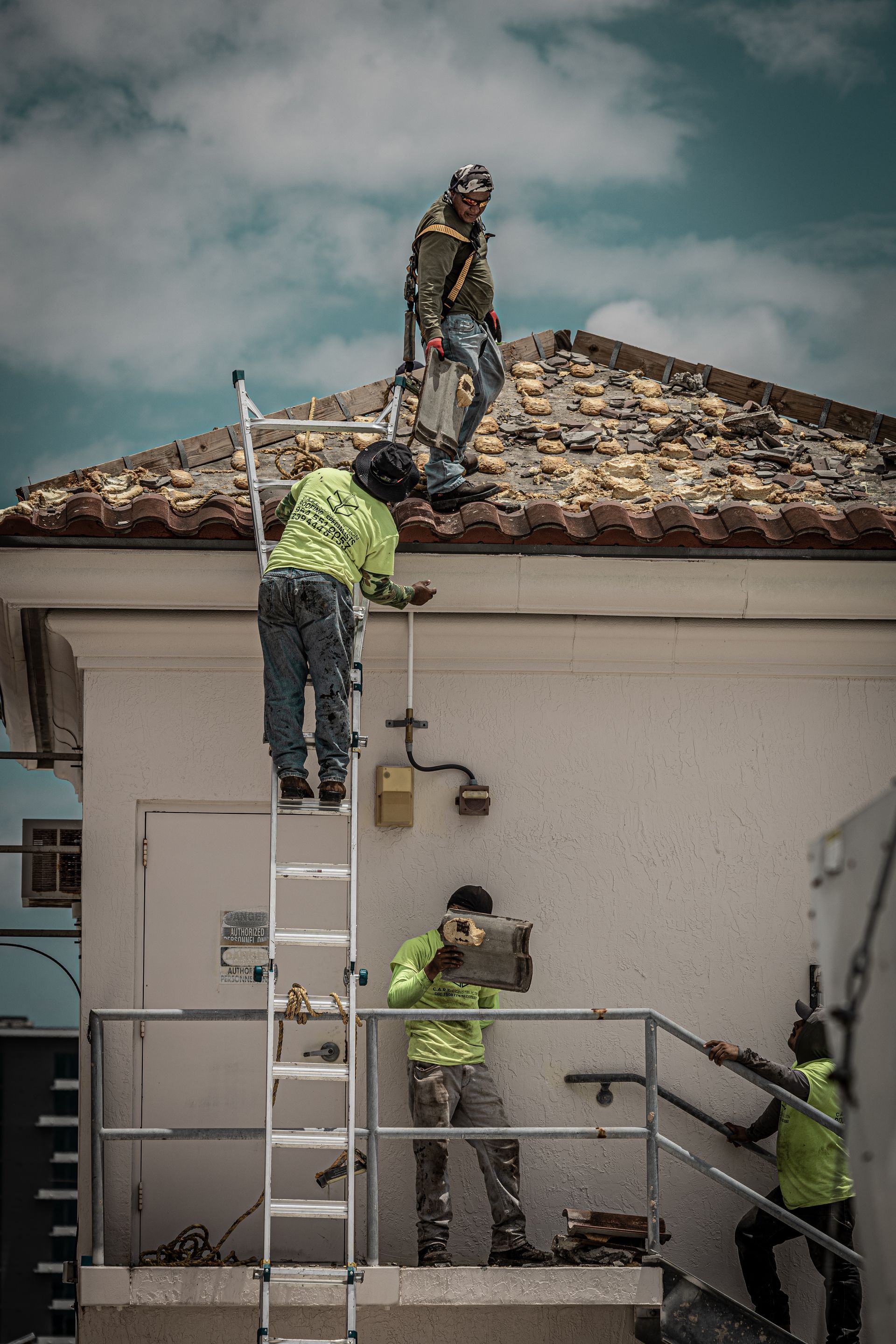 A group of construction workers are working on the roof of a building.