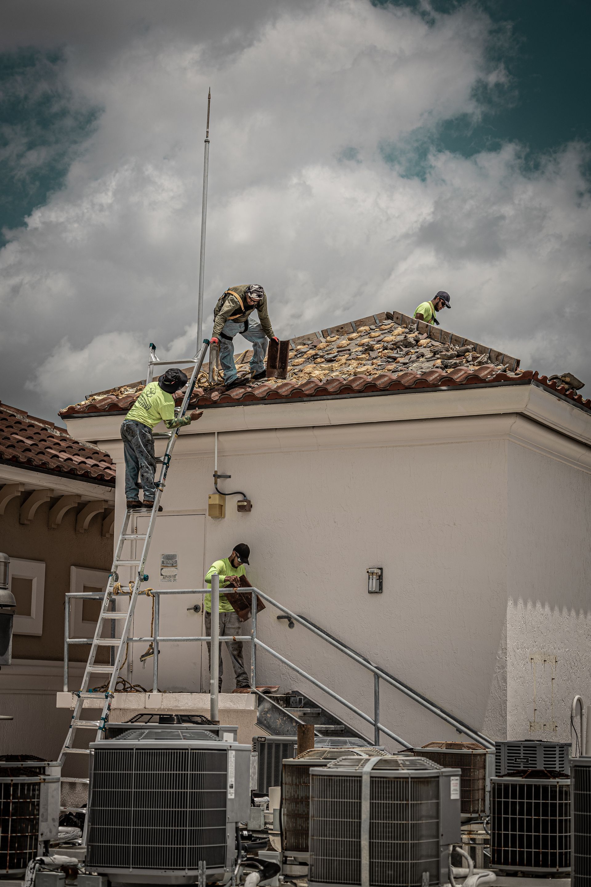 A group of people are working on the roof of a house.