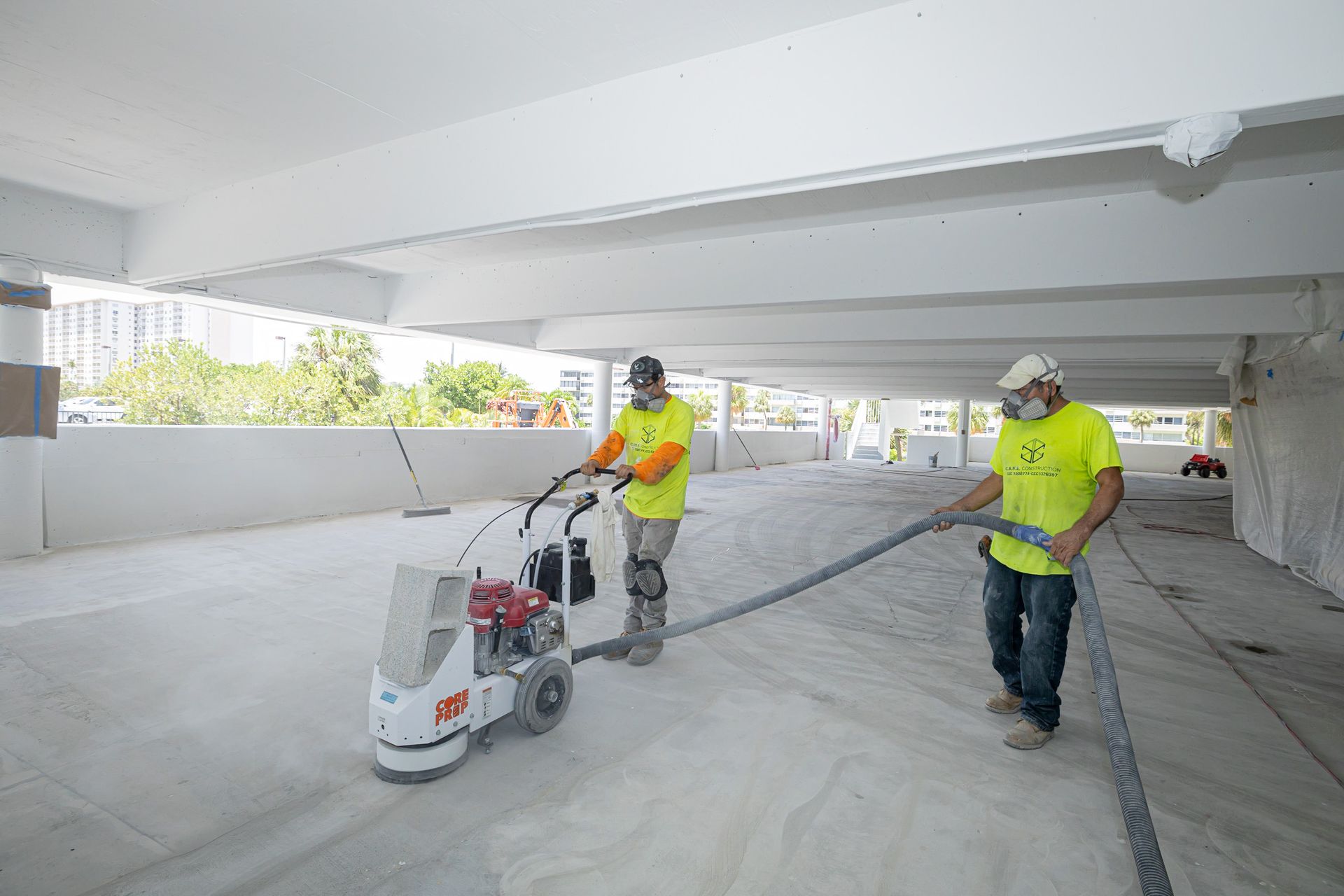 Two men are working on a machine in a parking garage.