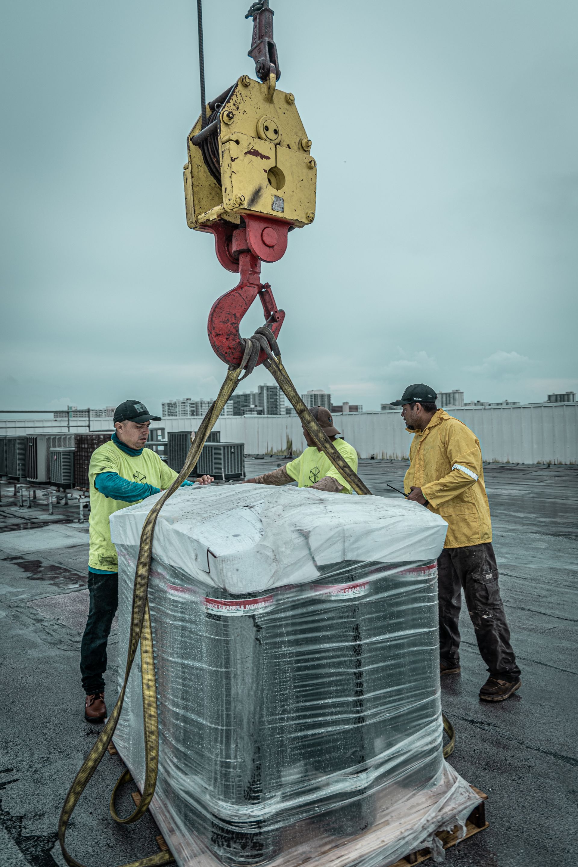 A group of men are lifting a large item with a crane.