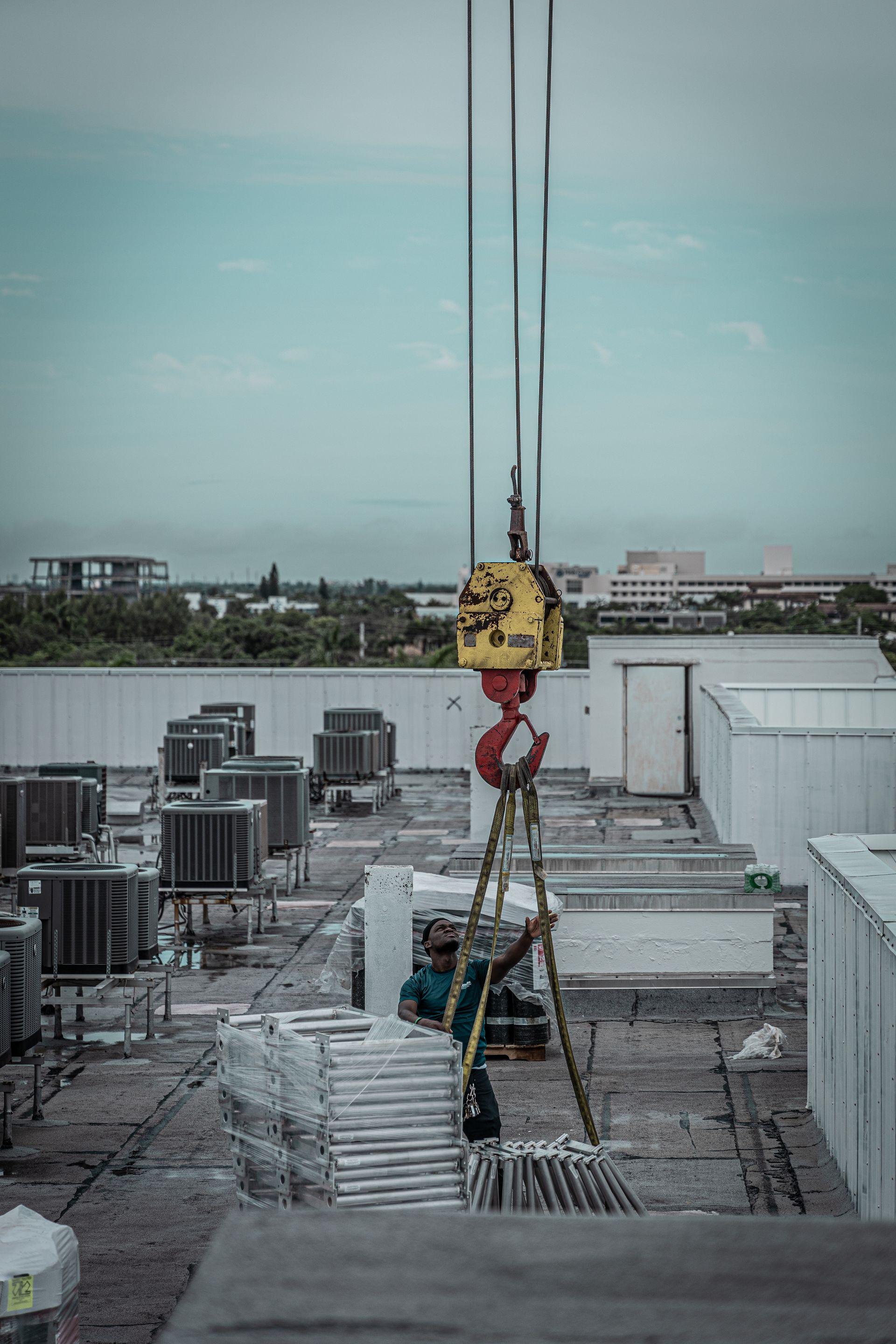 A crane is hanging from the roof of a building.