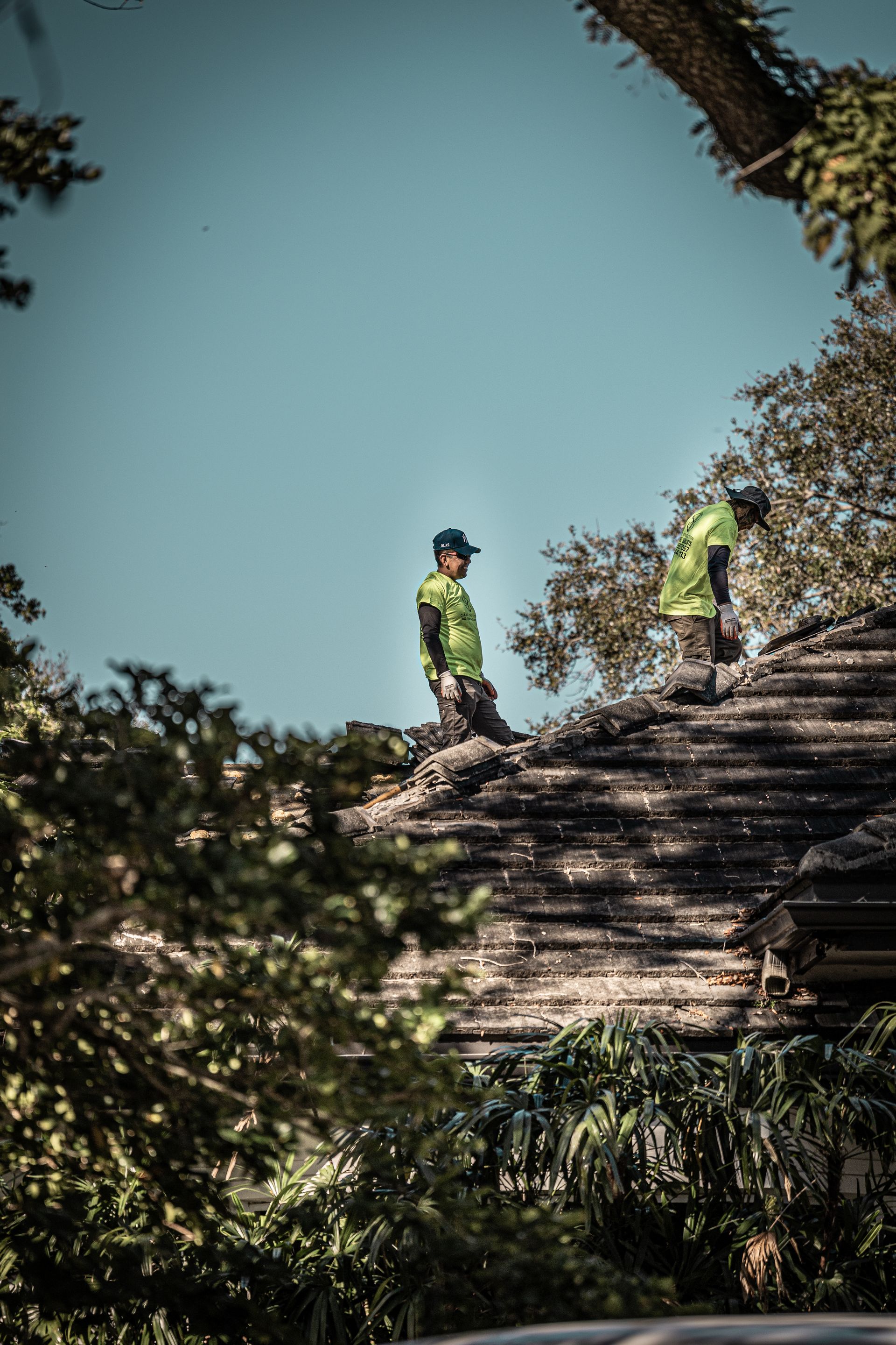 Two men are working on the roof of a house.