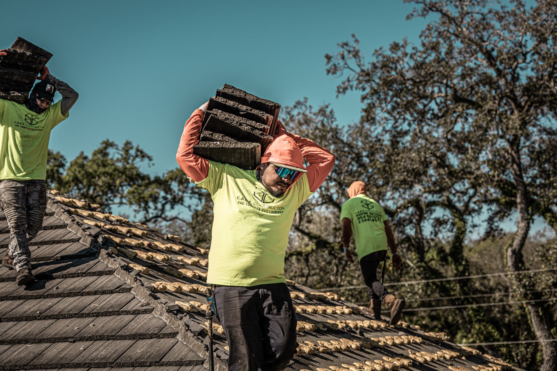 A man is carrying a stack of logs on his head.