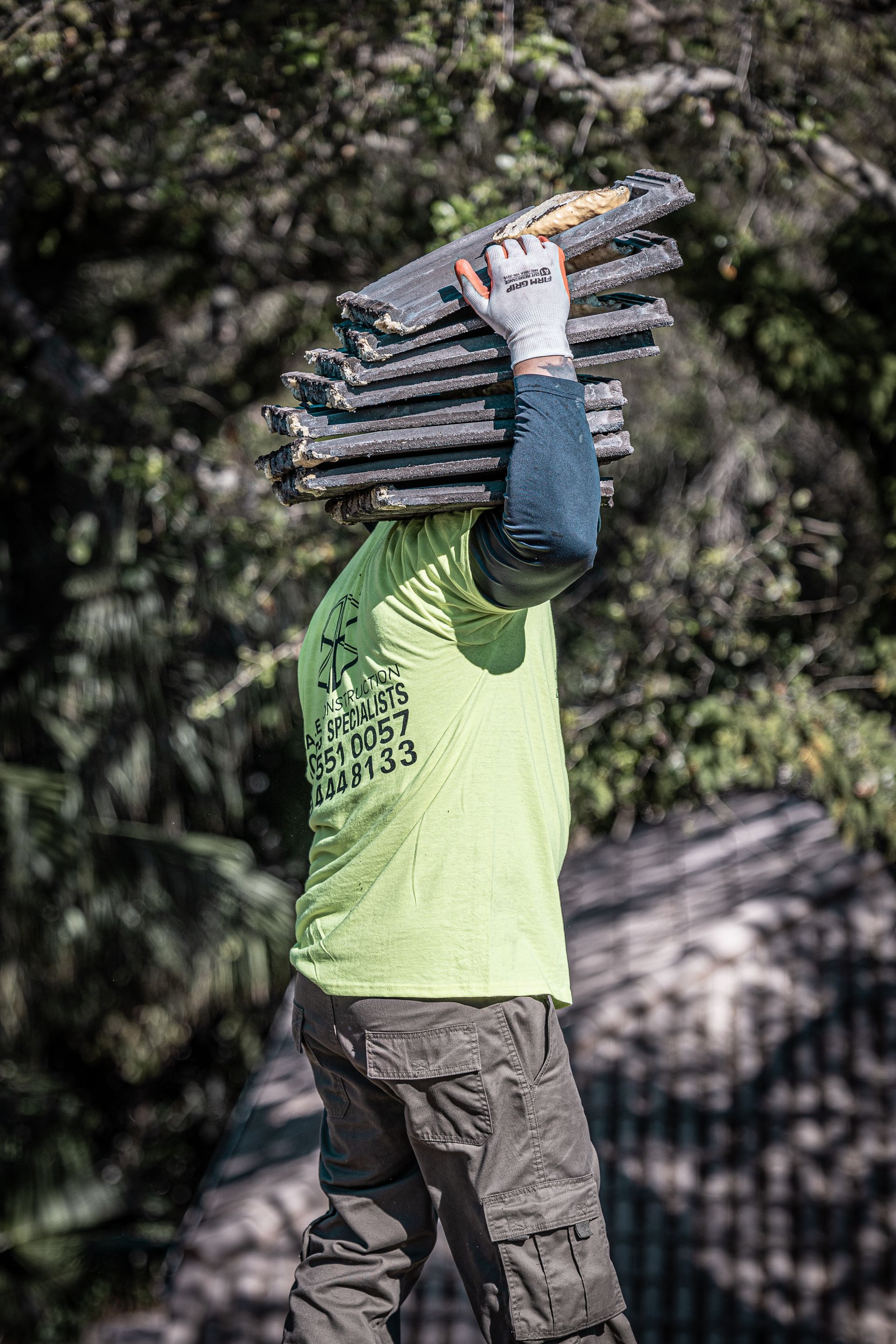 A man is carrying a stack of wood on his head.