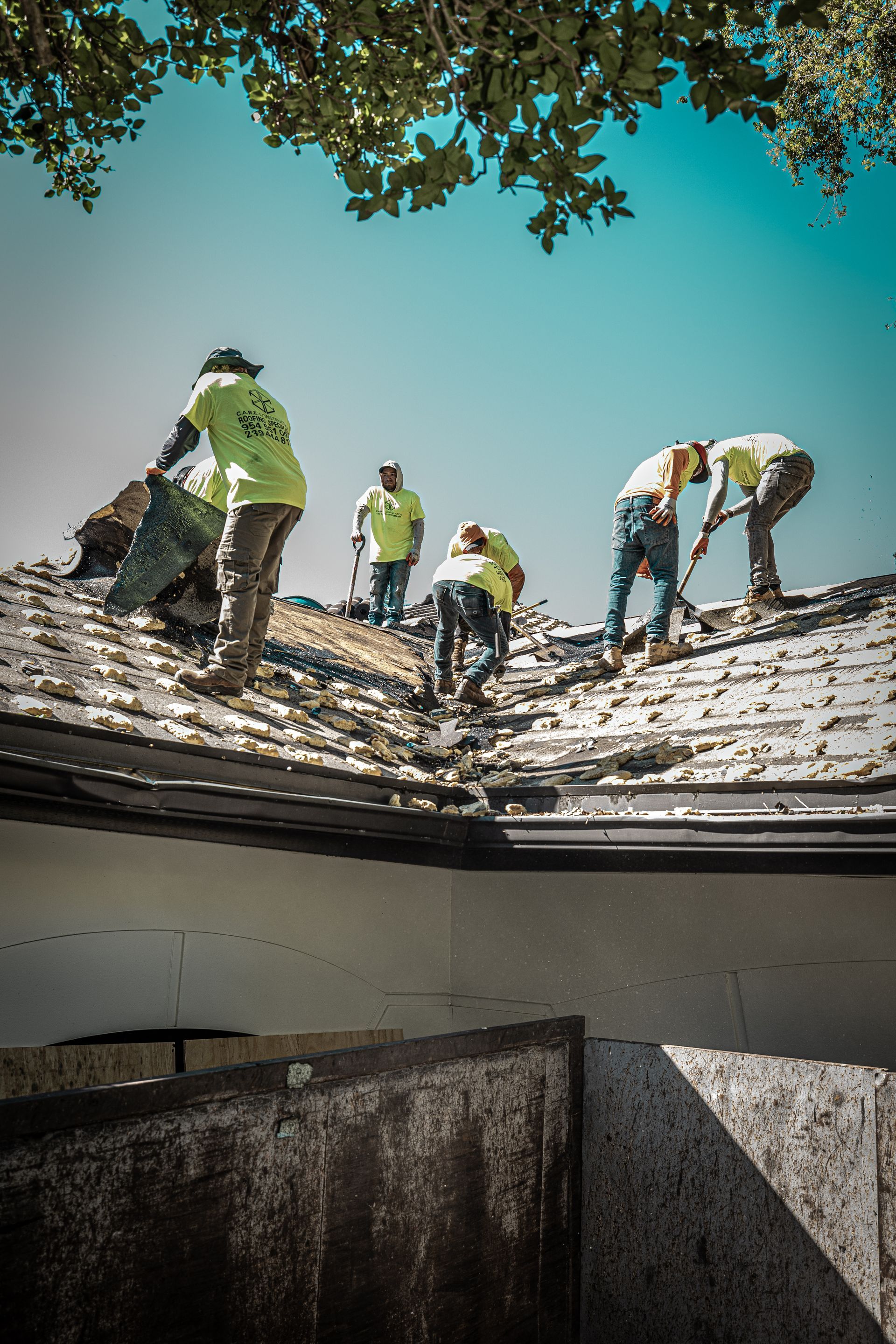 A group of men are working on the roof of a house.