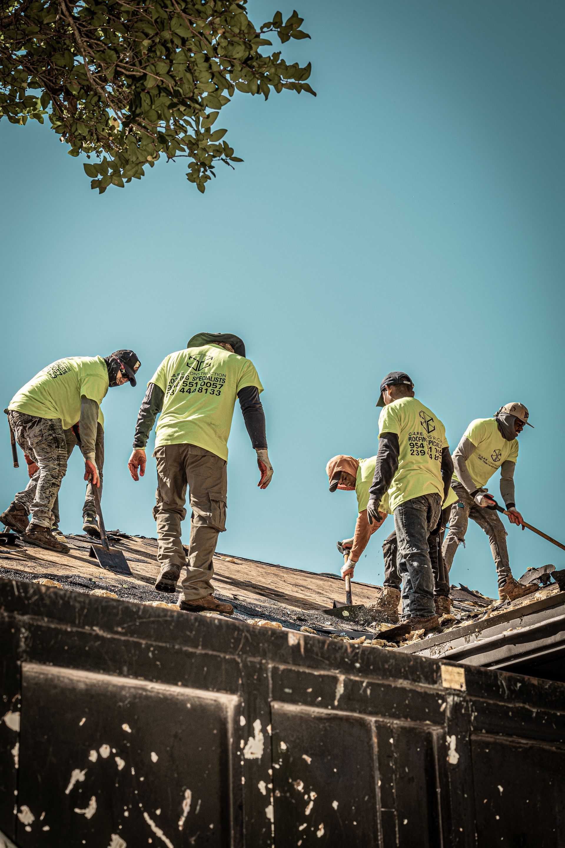 A group of construction workers are working on a roof.