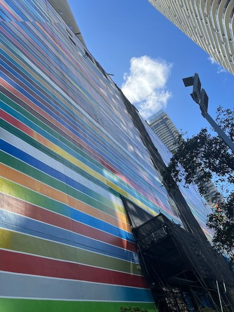 A colorful striped wall with a blue sky in the background