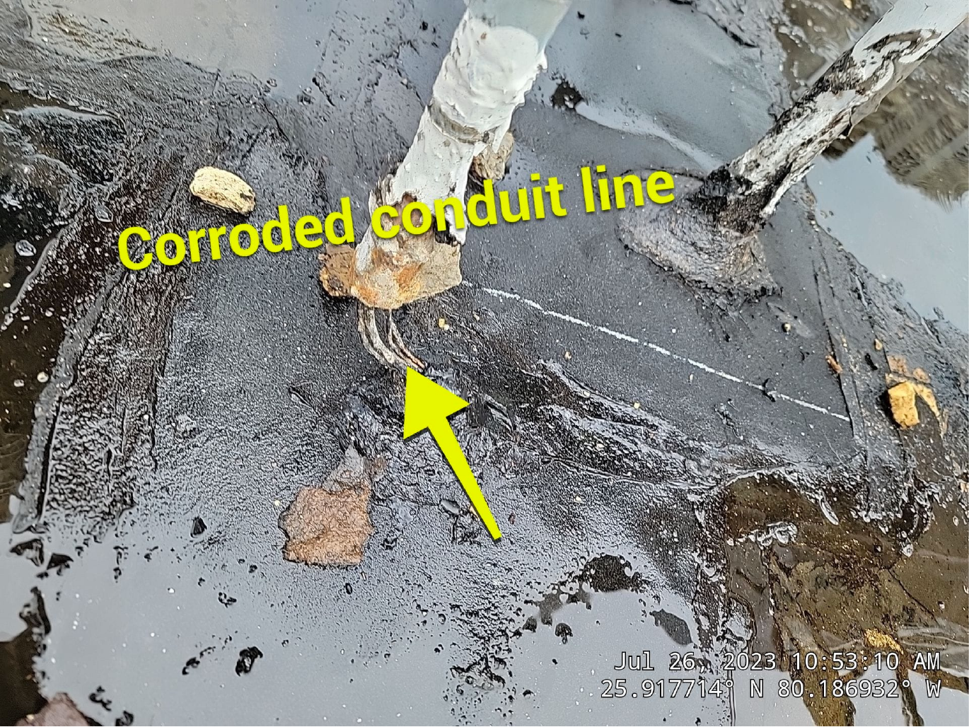 A yellow arrow points to a corroded conduit line