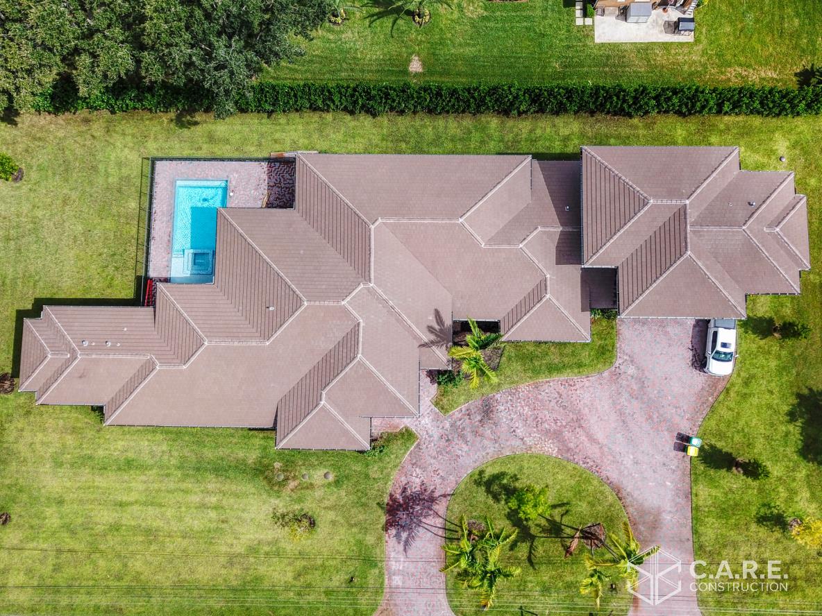 An aerial view of a large house with a pool in the backyard.