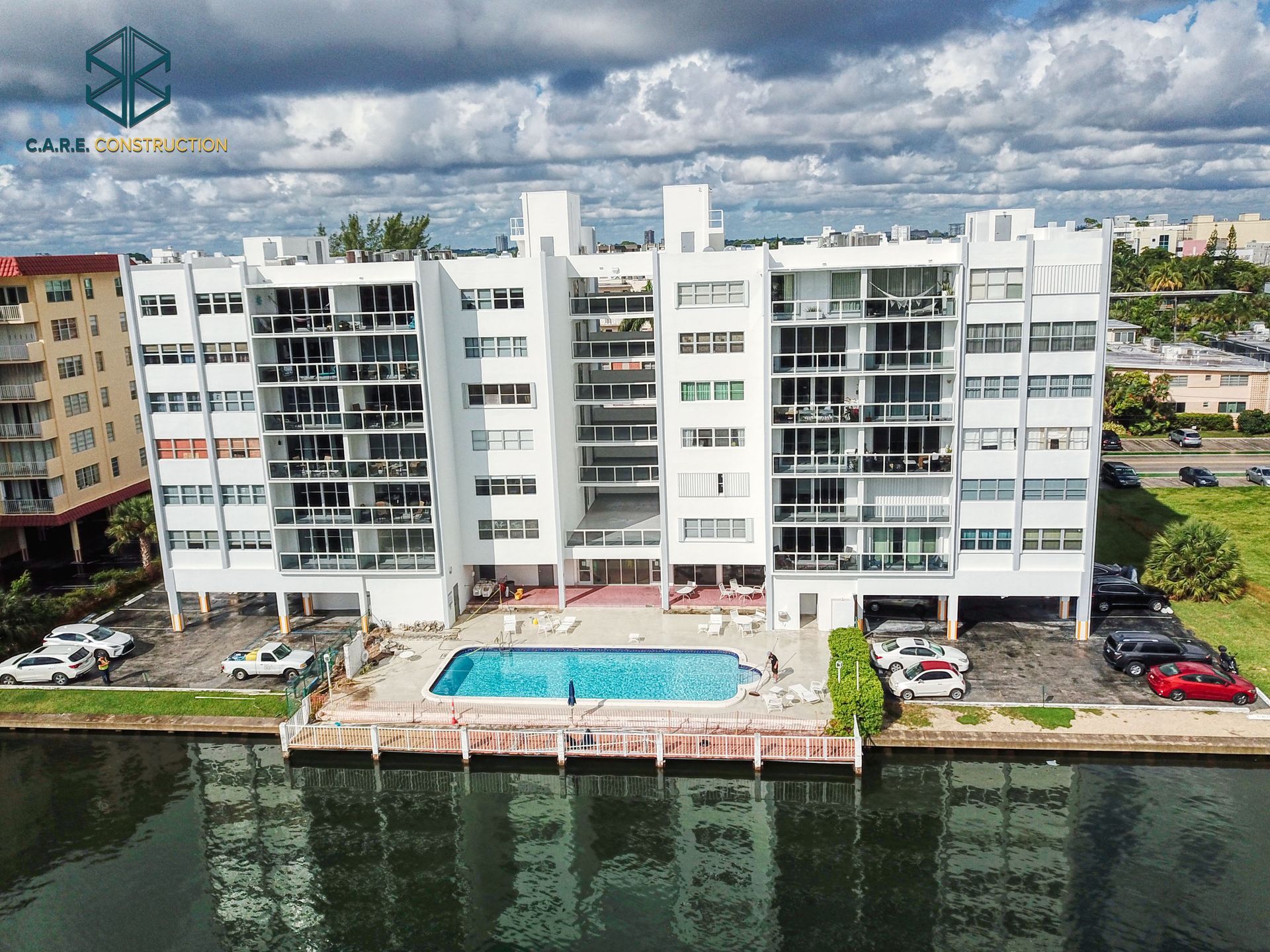 An aerial view of a building with a swimming pool in front of it