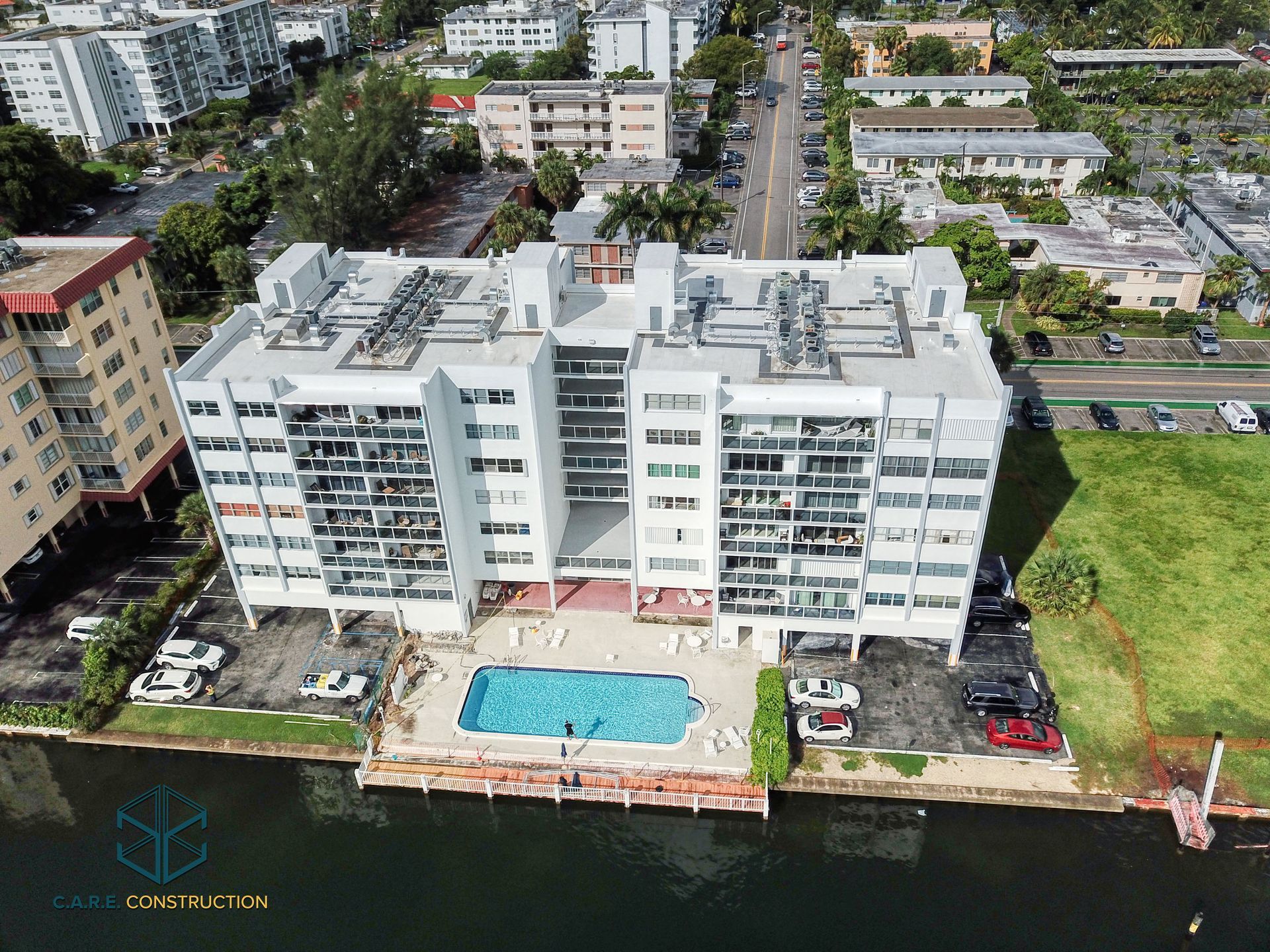 An aerial view of a building with a pool in front of it