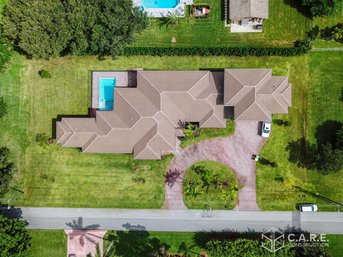 An aerial view of a house with a pool in the backyard.