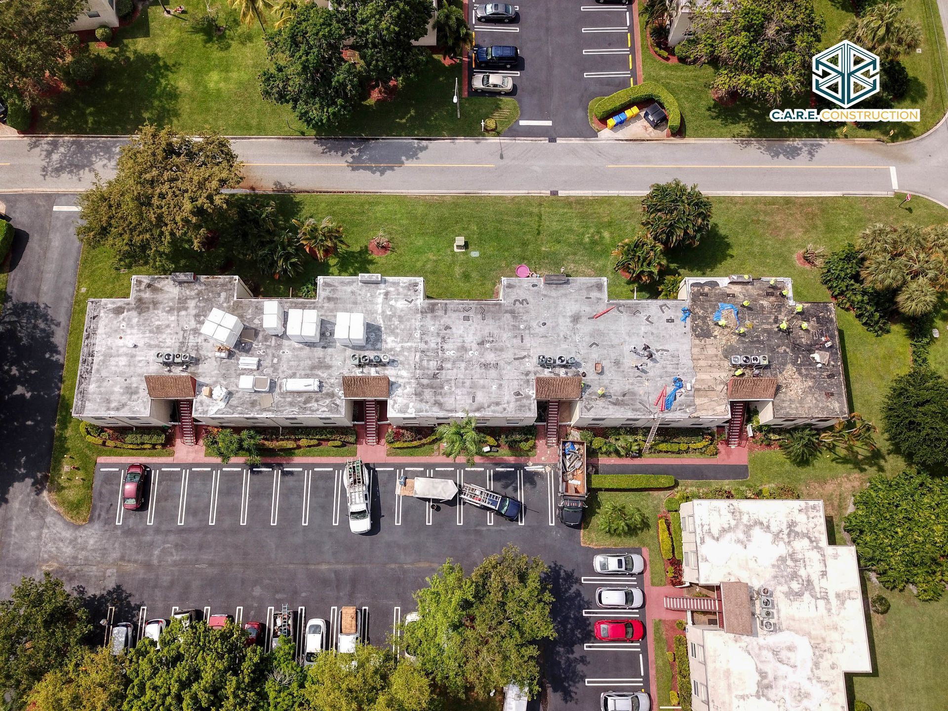 An aerial view of a building with a lot of cars parked in front of it.