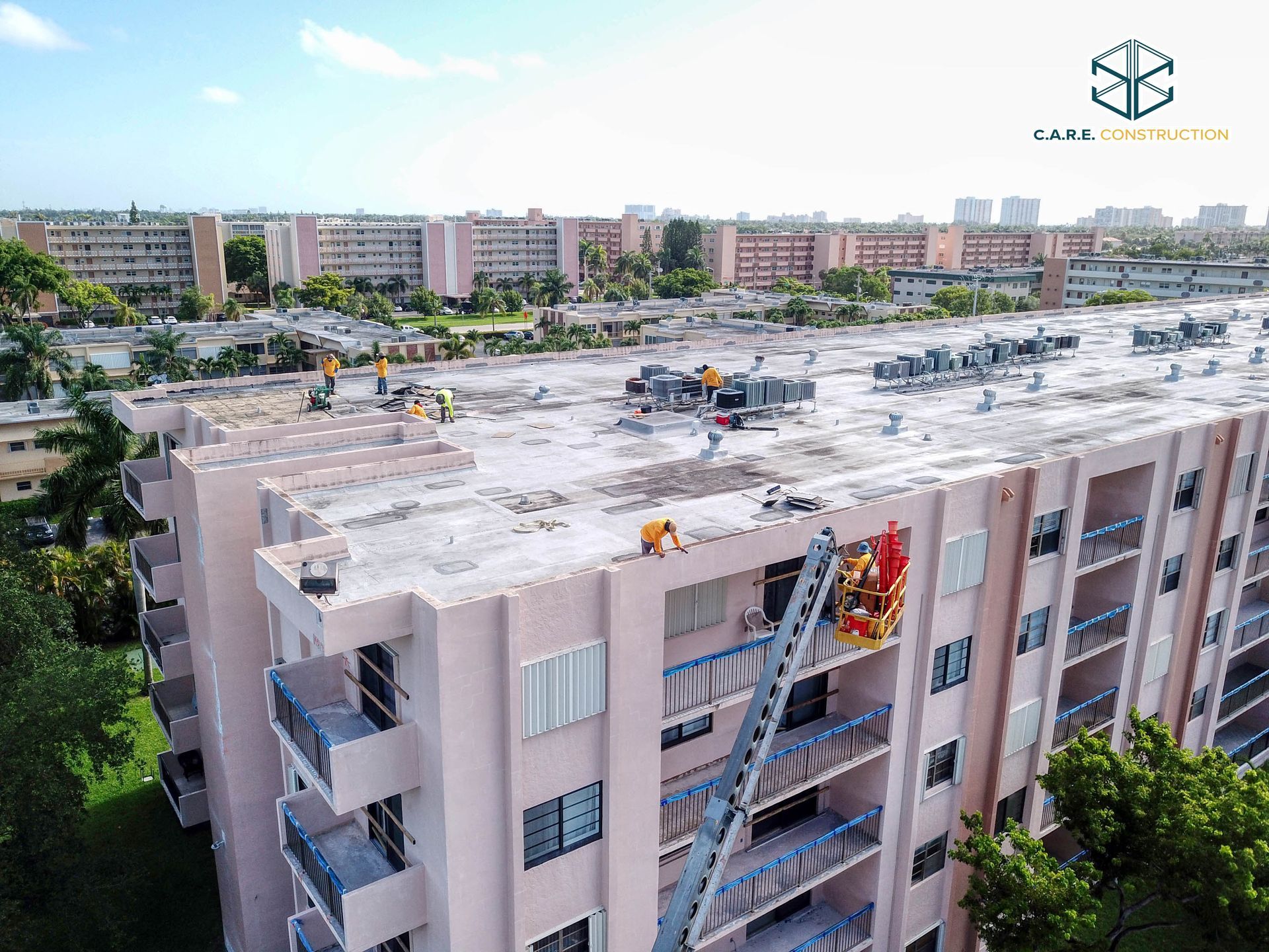 An aerial view of a building with workers on the roof.