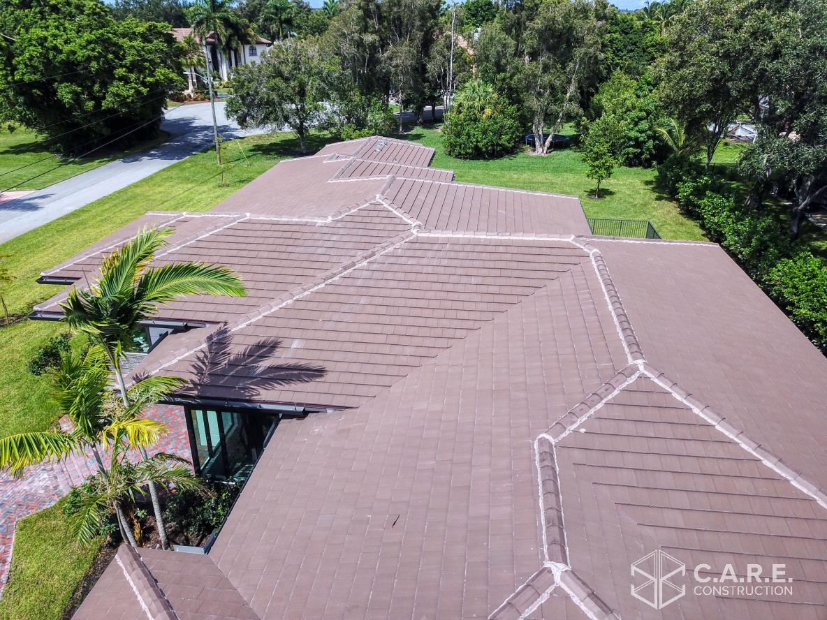 An aerial view of a roof of a house with trees in the background.