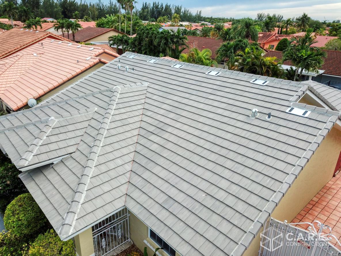 An aerial view of a house with a tiled roof surrounded by trees.