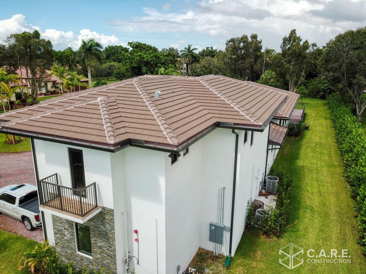 An aerial view of a house with a brown roof and a white truck parked in front of it.