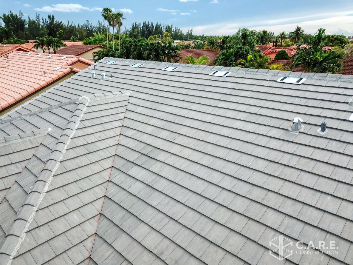 An aerial view of a tiled roof with trees in the background.