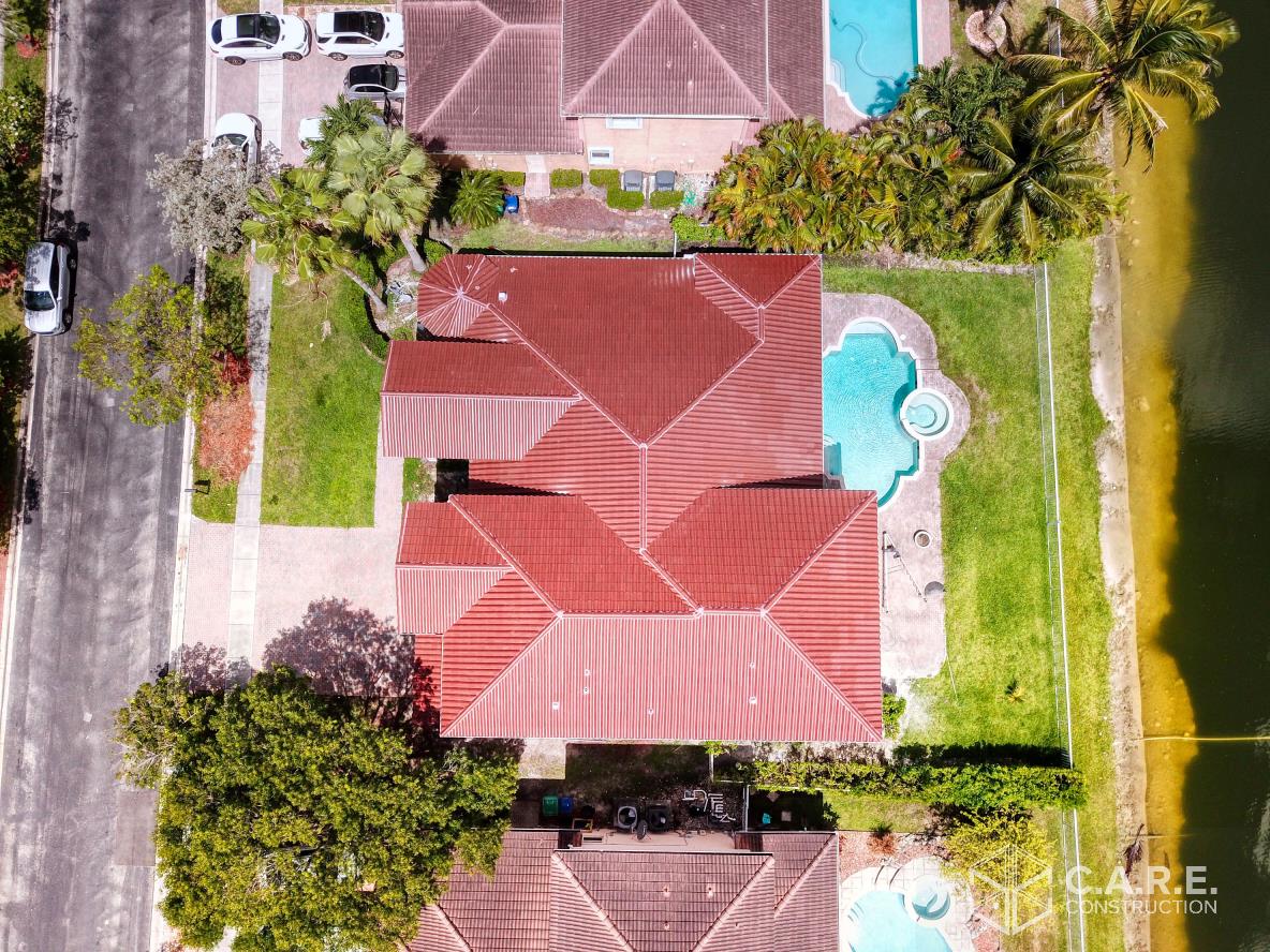 An aerial view of a house with a pool in the backyard.