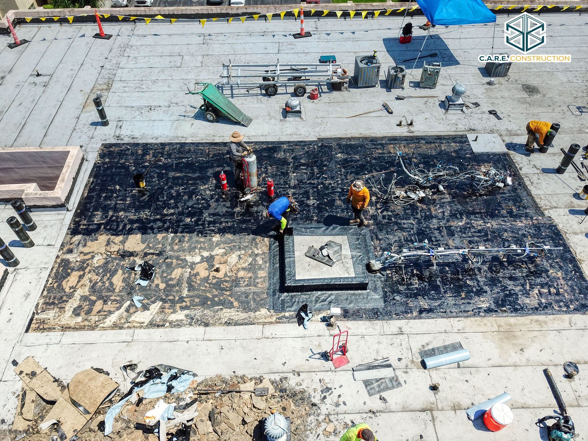 An aerial view of a roof with workers working on it.