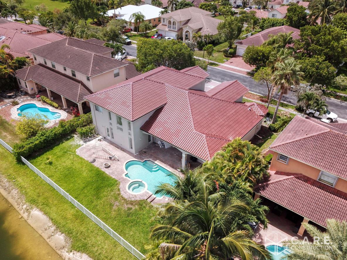 An aerial view of a residential area with houses and a pool.