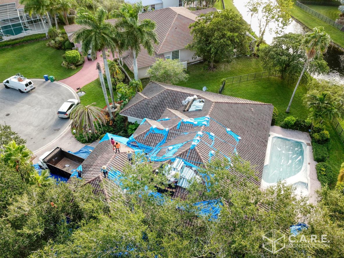 An aerial view of a house with a pool and a car parked in front of it.