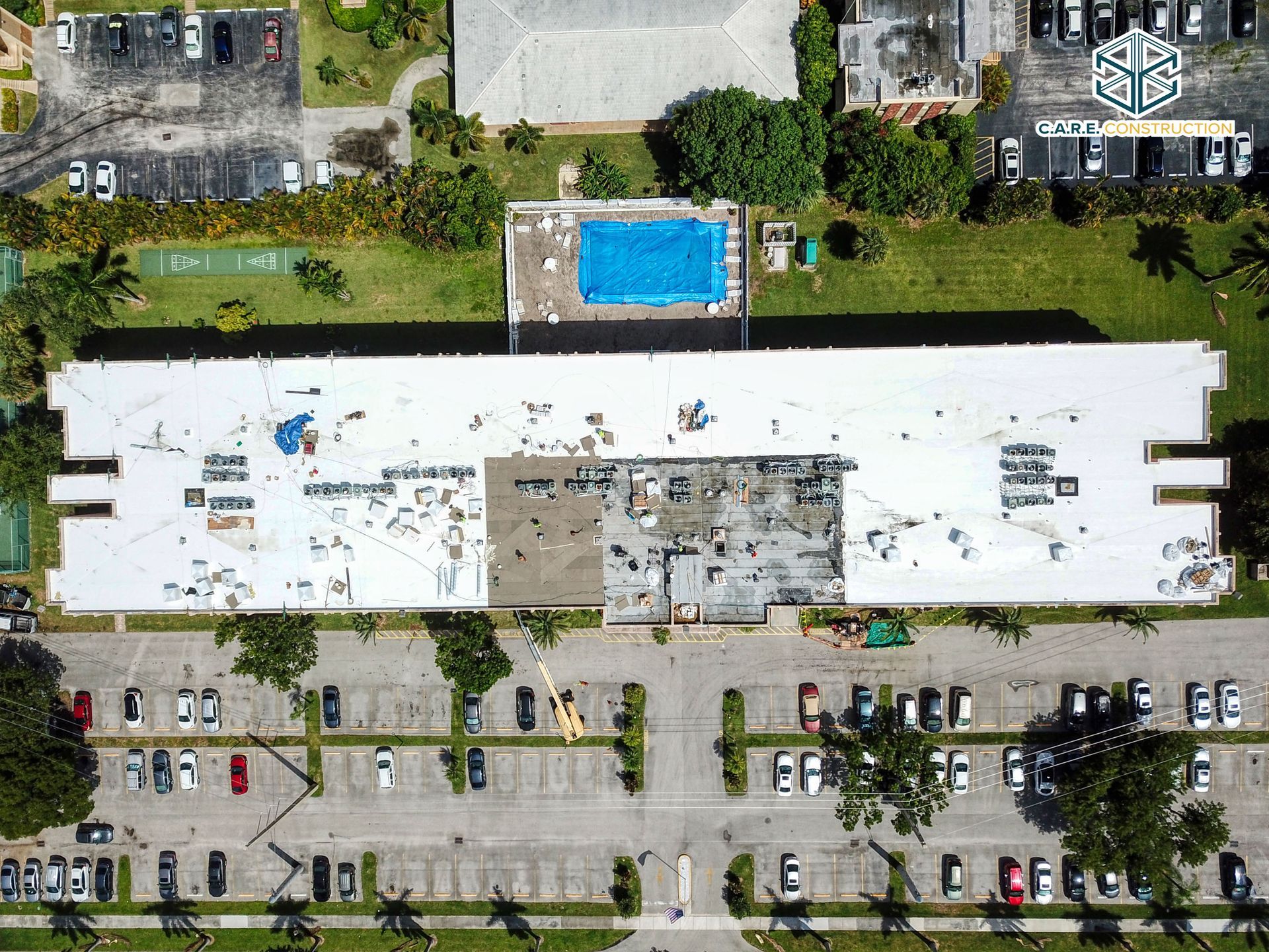 An aerial view of a large building with a pool in the background