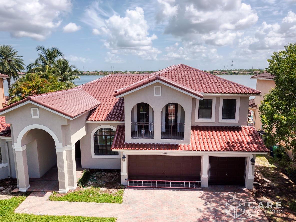 An aerial view of a large house with a red tile roof