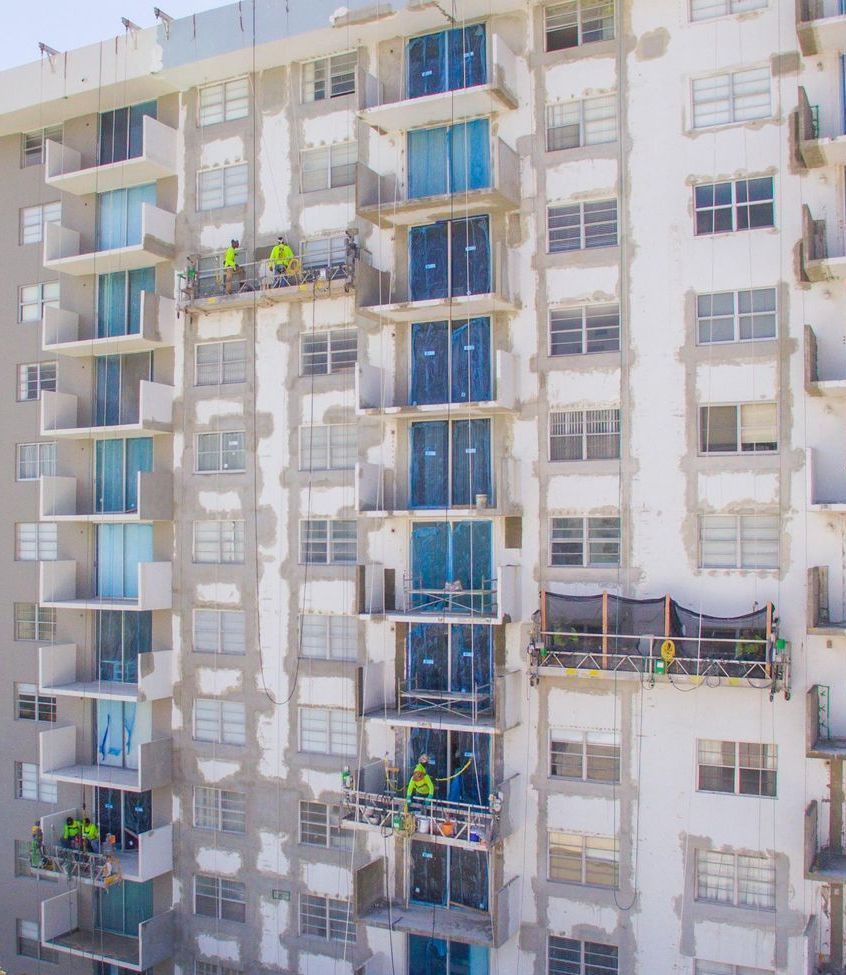 A group of people are working on the side of a building