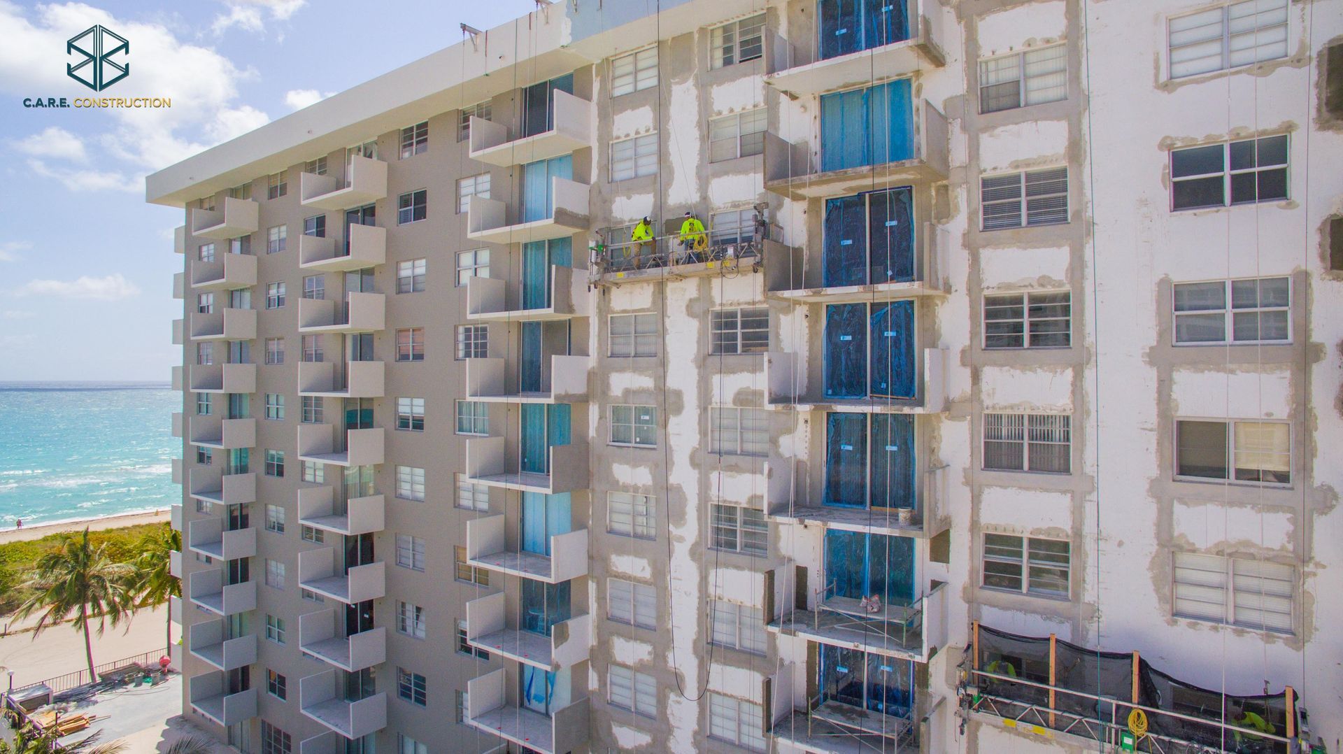 An aerial view of a tall building under construction next to the ocean.