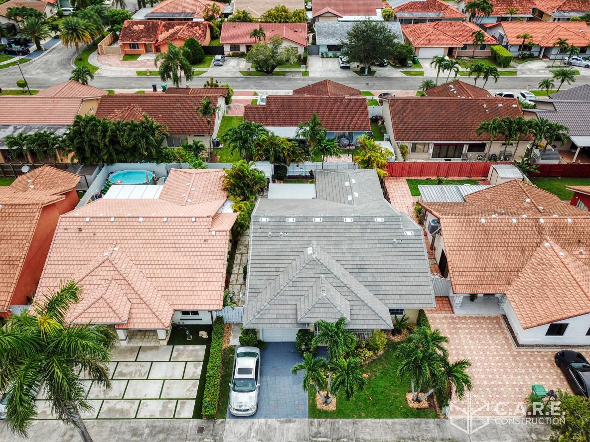 An aerial view of a house with a car parked in front of it in a residential area.
