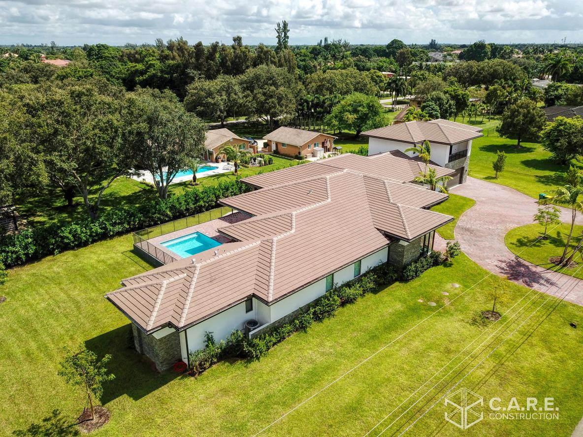 An aerial view of a large house with a pool in the backyard.