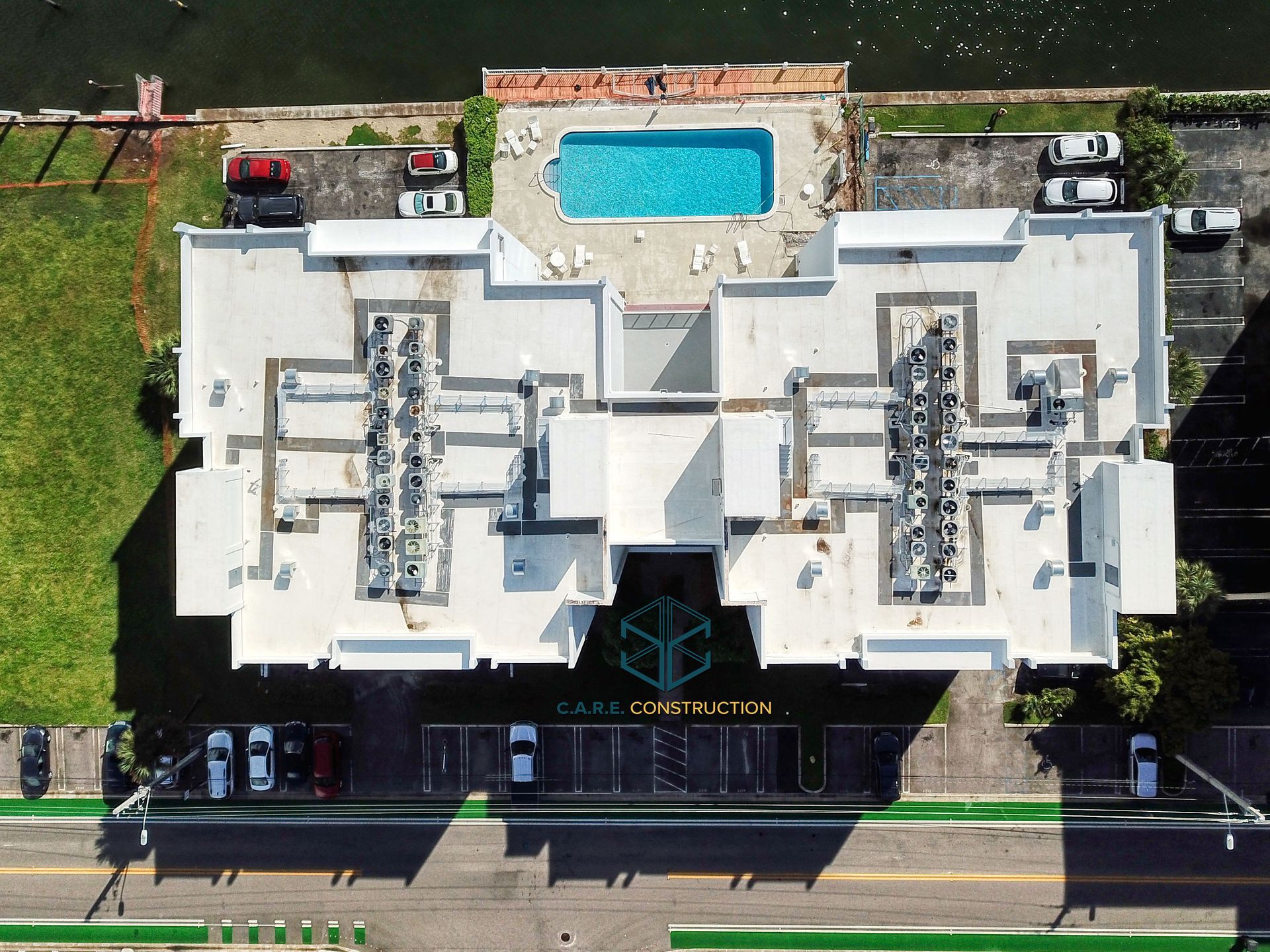 An aerial view of a building with a pool on the roof