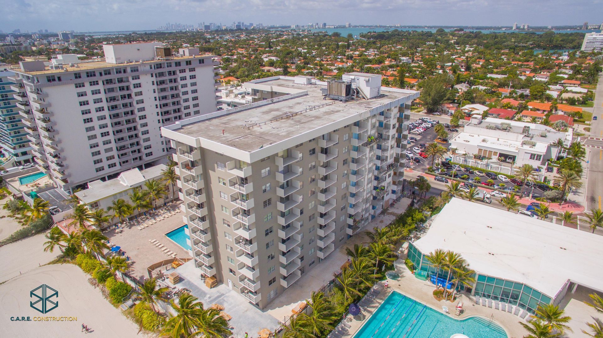 An aerial view of a city with a large building and a swimming pool