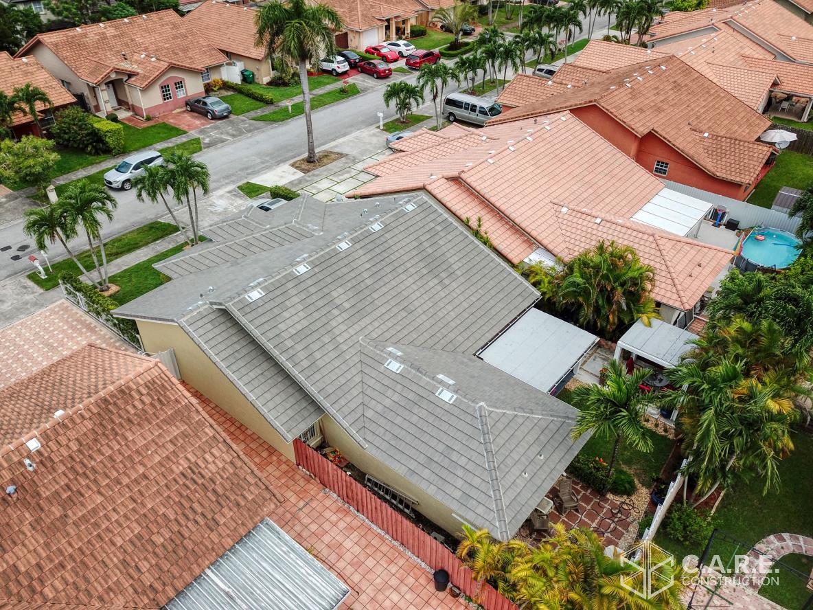 An aerial view of a residential area with houses and a pool.
