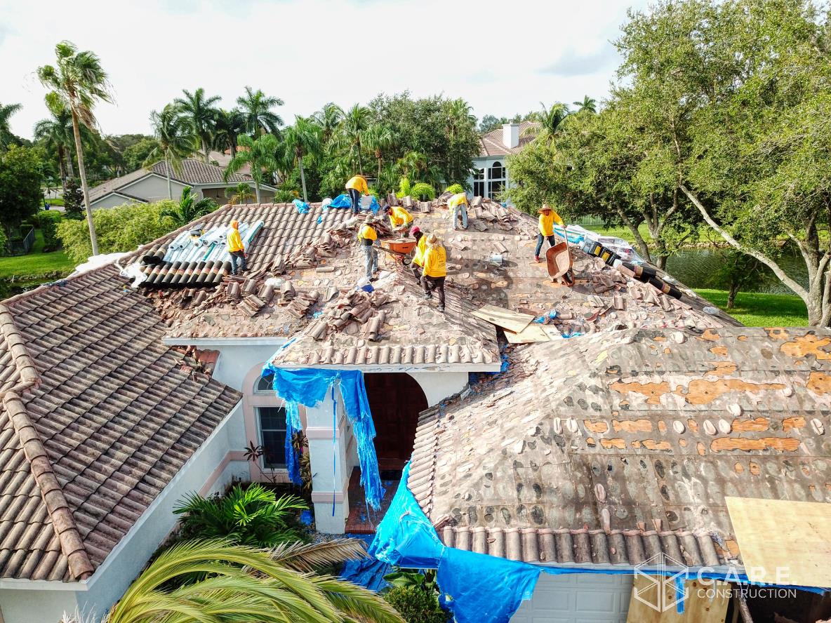 A group of people are working on the roof of a house.