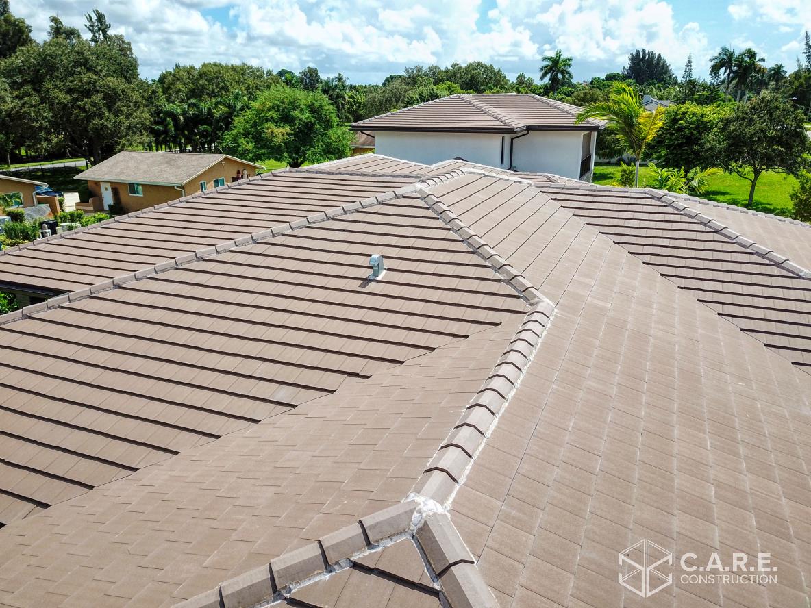 An aerial view of a roof of a house with trees in the background.
