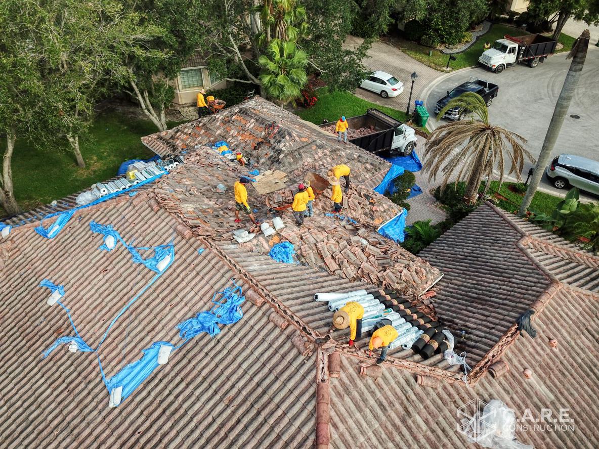 A group of men are working on the roof of a house.