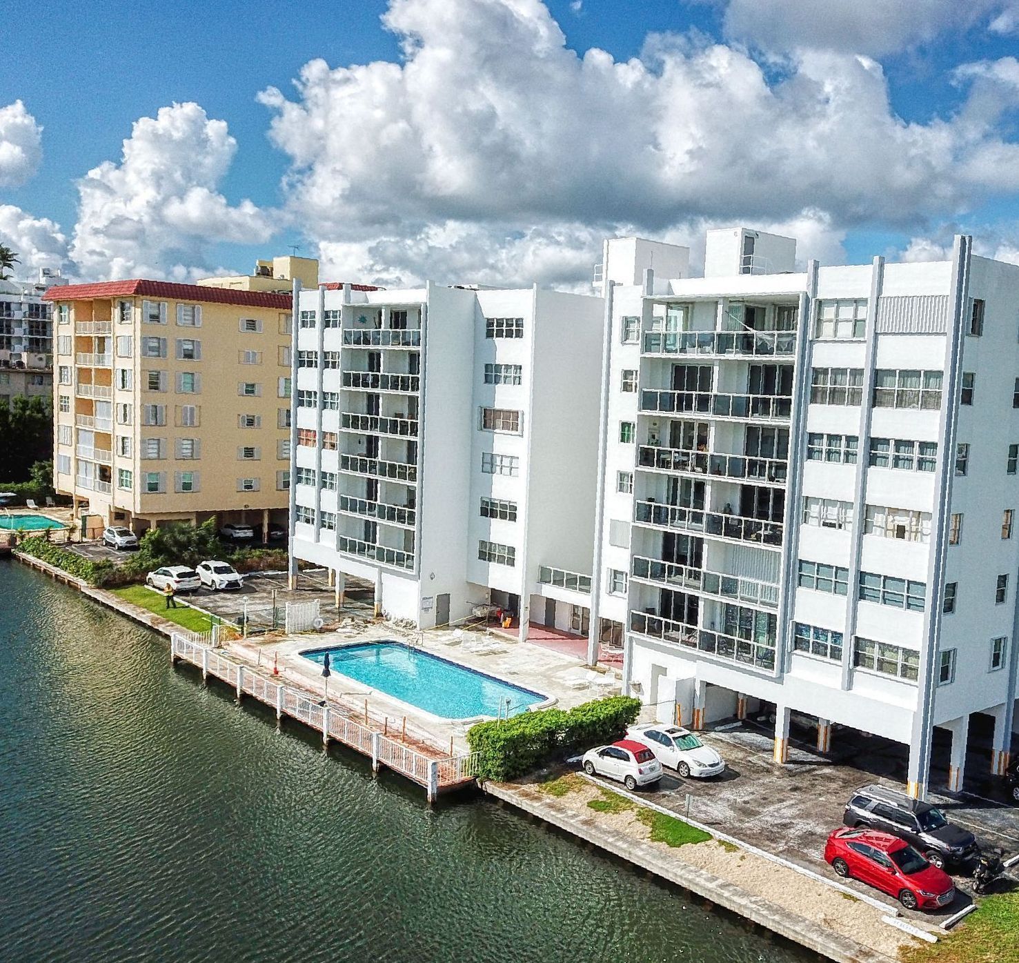 An aerial view of a building with a pool in front of it