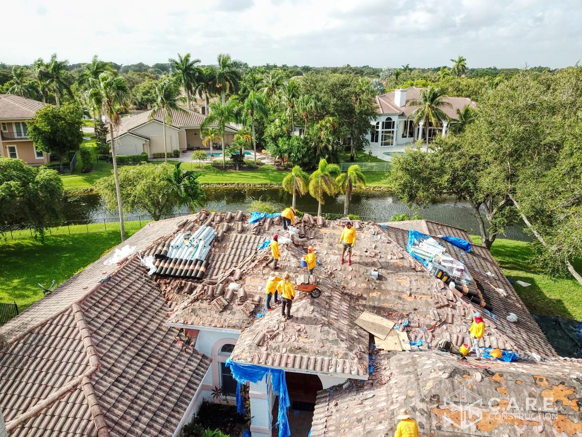 A group of people are working on the roof of a house.